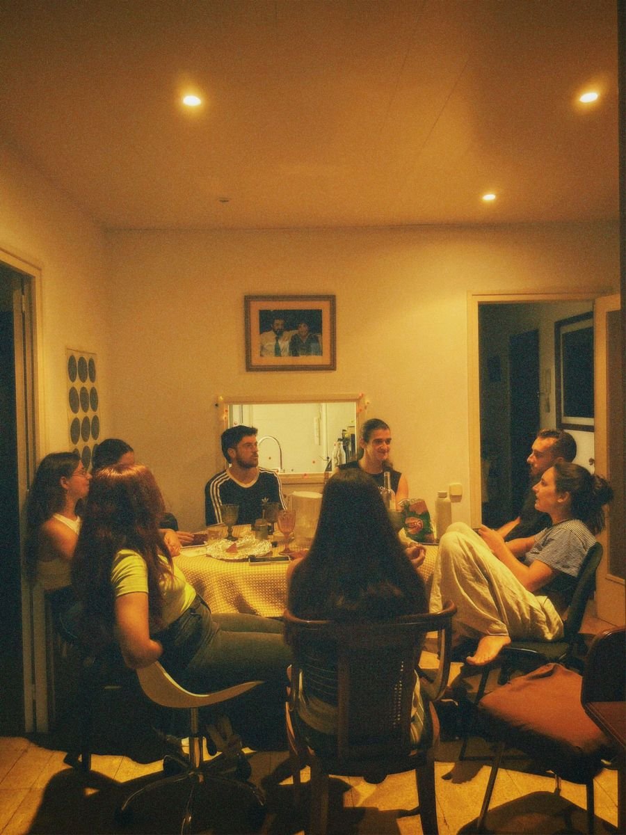 Un grupo de amigos conversa alrededor de una mesa durante una cena